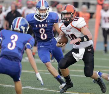 lake junior defensive back nick bruner 3 and and senior linebacker ryan delagrange 8 surround green quarterback blake suponcic 10 as he looks for a hole to run the ball in a week 1 game