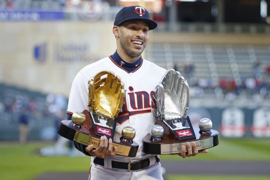 FILE - Minnesota Twins' Carlos Correa walks off the field with his 2021  Golden Glove and Platinum Glove awards presented to him prior to a baseball  game with the Seattle Mariners, Monday