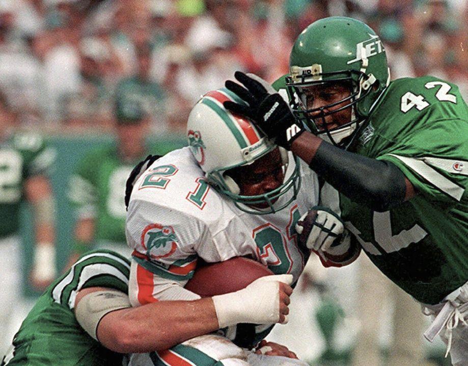 New York Jets Ronnie Lott, right, and teammate Jeff Lageman, left, take  down Miami Dolphins Mark Higgs at Joe Robbie Stadium in Miami, in this  September 13, 1993 photo. Lott will be